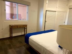 una camera da letto con un letto, un tavolo e una finestra di VIVO 2 Bedroom Ocean Front Condo 180 degree ocean views a Puerto Escondido Altre 32 foto