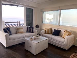 a living room with two couches and a coffee table at VIVO Residences 2 Bedroom Ocean Front Condo 180 degree ocean views in Puerto Escondido