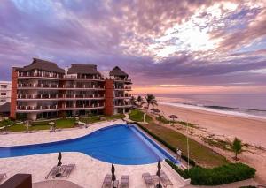 un resort con piscina vicino alla spiaggia di VIVO 2 Bedroom Ocean Front Condo 180 degree ocean views a Puerto Escondido