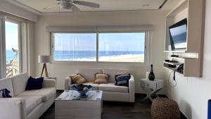 un soggiorno con divano e vista sulla spiaggia di VIVO 2 Bedroom Ocean Front Condo 180 degree ocean views a Puerto Escondido