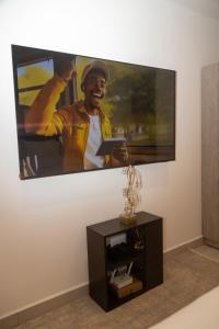 een grote flatscreen-tv aan een muur bij Urban Nook, The Bantree in Accra +3 foto's