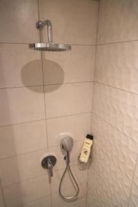 een douche met een föhn in de badkamer bij Urban Nook, The Bantree in Accra