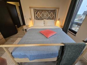 a bedroom with a bed with a red pillow on it at Tranquility Apartment Pirin Golf in Razlog