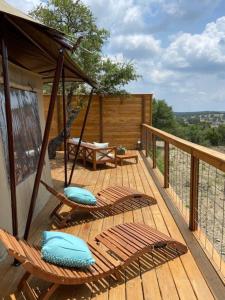 een veranda met stoelen en een schommel op een terras bij Premium Suite 1-Safari Tent-Private Hot Tub in Marble Falls