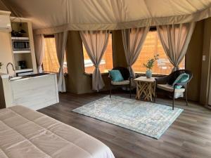 een slaapkamer met een bed, twee stoelen en een tafel bij Premium Suite 1-Safari Tent-Private Hot Tub in Marble Falls