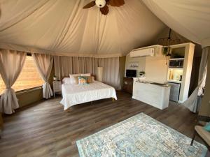 een slaapkamer met een bed en een plafondventilator bij Premium Suite 1-Safari Tent-Private Hot Tub in Marble Falls
