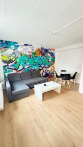 sala de estar con sofá y mural en Cosy 3 - Belfort centre, en Belfort