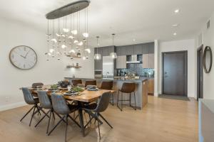 蒙特朗布朗Tremblant Prestige - Horizon 2-204的厨房以及带桌子和时钟的用餐室。