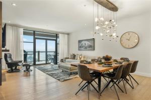 蒙特朗布朗Tremblant Prestige - Horizon 2-204的客厅里有一张桌子，墙上挂着一个钟 更多21张照片