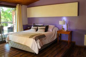 a bedroom with a large bed with purple walls at Estero El Claro Hotel y Cabañas in Pucón