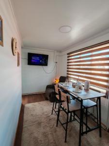 uma sala de estar com uma mesa, cadeiras e um sofá em Ruka Austral em Punta Arenas mais 3 fotografias