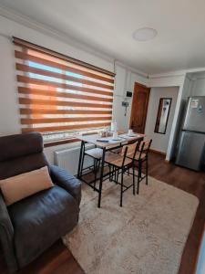 uma sala de estar com uma mesa, cadeiras e um sofá em Ruka Austral em Punta Arenas