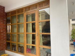 a window with wooden doors on a building at Rooftop Shantiniketon in Dhaka