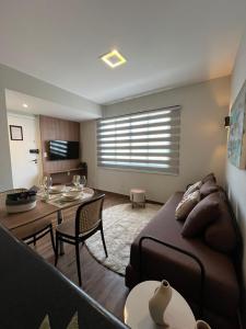 un soggiorno con un divano e un tavolo di Flat Praia do Canto Collection View a Vitória