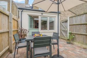a table and chairs with an umbrella on a patio at 2 Bed in Pakefield oc-p32922 in Lowestoft
