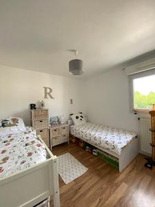 a bedroom with two beds and a window at Le cocon chaleureux in Vannes +3 photos