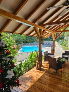 Beach resort playa Leona في Gigantes: سطح خشبي مع كراسي ومسبح