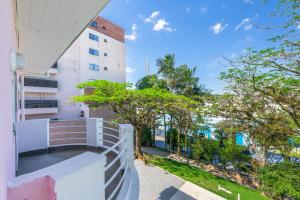 Pousada Encanto da Vila في بلوميناو: شرفة شقة مع أشجار ومبنى