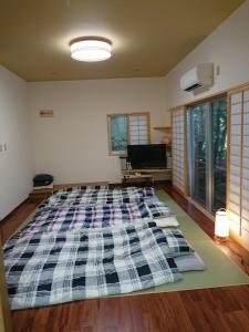 a large bed in the middle of a room at Big Tree JUDO ハウス in Urasoe