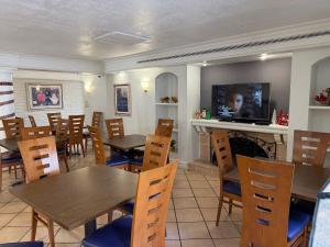 a restaurant with wooden tables and chairs and a fireplace at La Quinta by Wyndham Pinellas Park St Peterburg Clearwater in Pinellas Park