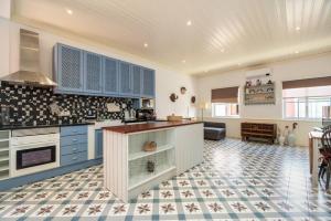 シルヴェスにあるTerracotaのタイルフロアのキッチン(青いキャビネット付)