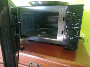 a microwave oven sitting on top of a wooden cabinet at TABERNA ROMANA VILLA OCA b&b in Velletri