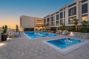 un'immagine di un edificio con piscina di Crowne Plaza Al Jubail by IHG a Al Fanātīr