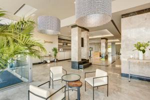 Sercotel Ciutat de Montcada في مونتكاذا: ردهة بها كراسي وطاولة في مبنى