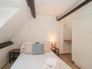 1 dormitorio con 1 cama blanca en el ático en 6 Priory Lane, en Burford