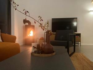 a living room with a table with a vase and a fireplace at Himmel & Holz in Saal