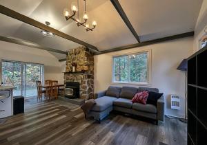 Le Colibri في Saint Come: غرفة معيشة مع أريكة ومدفأة حجرية