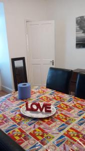 uma mesa com um sinal de amor em cima dela em Cozy & Comfy Apartments Dundee em Dundee