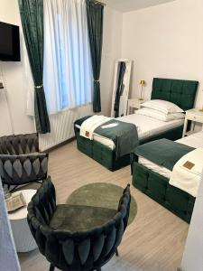 ein Hotelzimmer mit zwei Betten und einem Stuhl in der Unterkunft Tudors Rooms in Mediaş