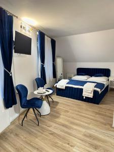 ein Schlafzimmer mit einem Bett, einem Tisch und Stühlen in der Unterkunft Tudors Rooms in Mediaş