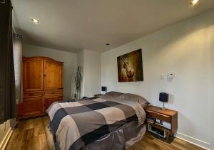 Le Colibri في Saint Come: غرفة نوم بها سرير ولوحة على الحائط