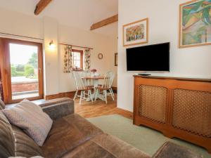 een woonkamer met een bank en een flatscreen-tv bij Ticklepenny in Cornisholme