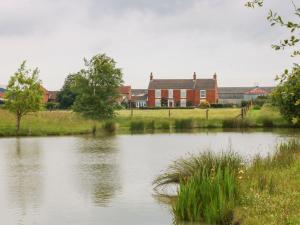 een huis naast een vijver voor een huis bij Ticklepenny in Cornisholme