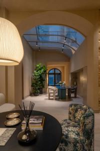 un soggiorno con un tavolo e una sedia di Palazzo Balsamo Boutique Hotel a Palermo