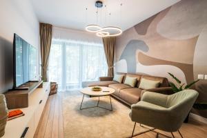 a living room with a couch and a tv at Best Residence - High-End Suites - by Solinis Homes in Bucharest
