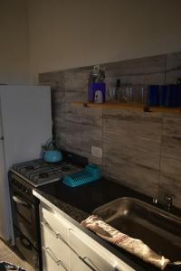 a kitchen with a stove and a stainless steel sink at Villa del Sol Complejo in Liebig
