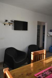 a living room with a table and a chair and a television at Villa del Sol Complejo in Liebig