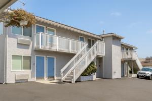 Un edificio de apartamentos con escaleras en un estacionamiento. en Pacific Inn Monterey, en Monterey