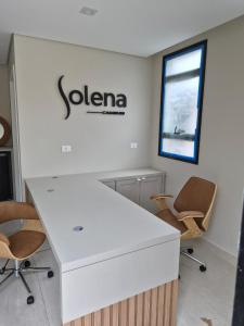 an office with a white desk and two chairs at Solena in Camburi