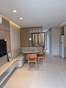 a kitchen with a table and two chairs in a room at Solena in Camburi