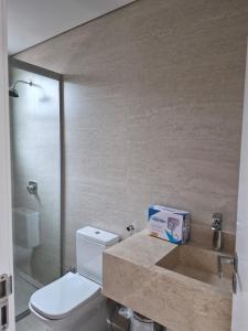 a bathroom with a toilet and a glass shower at Solena in Camburi