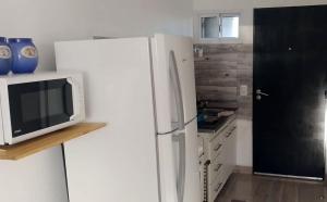 a kitchen with a white refrigerator and a microwave at Villa del Sol Complejo in Liebig +4 photos