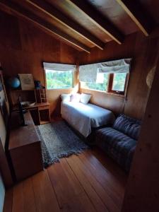 Un dormitorio con una cama y un sofá en una habitación. en Preciosa casa rural, Llau llao,Castro, Chiloé, en Castro