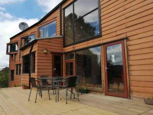 una casa con una mesa y sillas en una terraza en Preciosa casa rural, Llau llao,Castro, Chiloé, en Castro