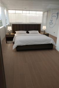 um quarto grande com uma cama grande e duas mesas de cabeceira em La Retama Houstime em Ayacucho