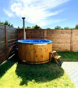 a hot tub in a backyard with a fence at Loft House Rozewie , BALIA OGRODOWA,oraz SAUNA in Jastrzębia Góra